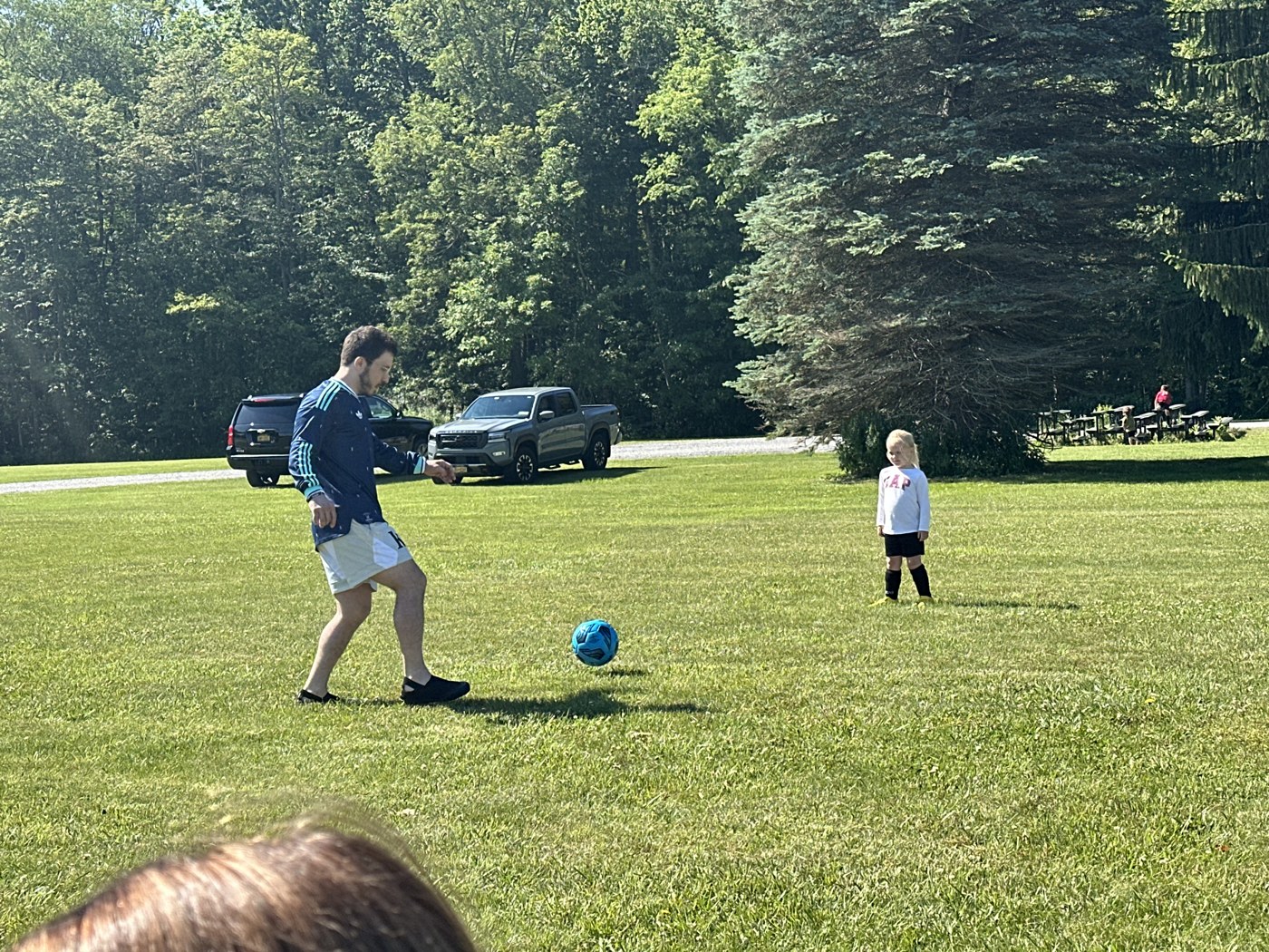 Ross playing soccer outdoors with a child